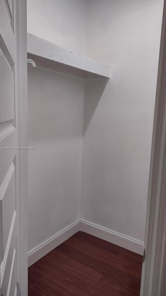 A small, empty closet features white walls, a single shelf, and wood-look flooring — 13301 NW 31st Ave # 1, Opa-Locka FL 33054, OPA-LOCKA, FL