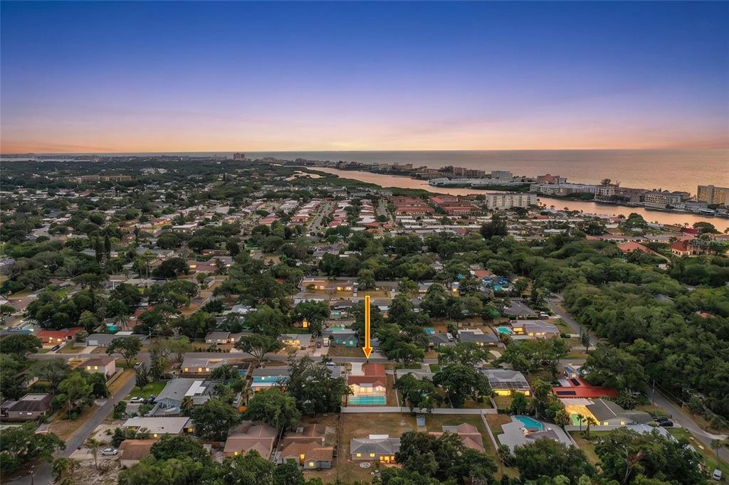 An aerial view shows a residential neighborhood with a house featuring a backyard swimming pool — 14803 SUNSET DRIVE, LARGO, FL