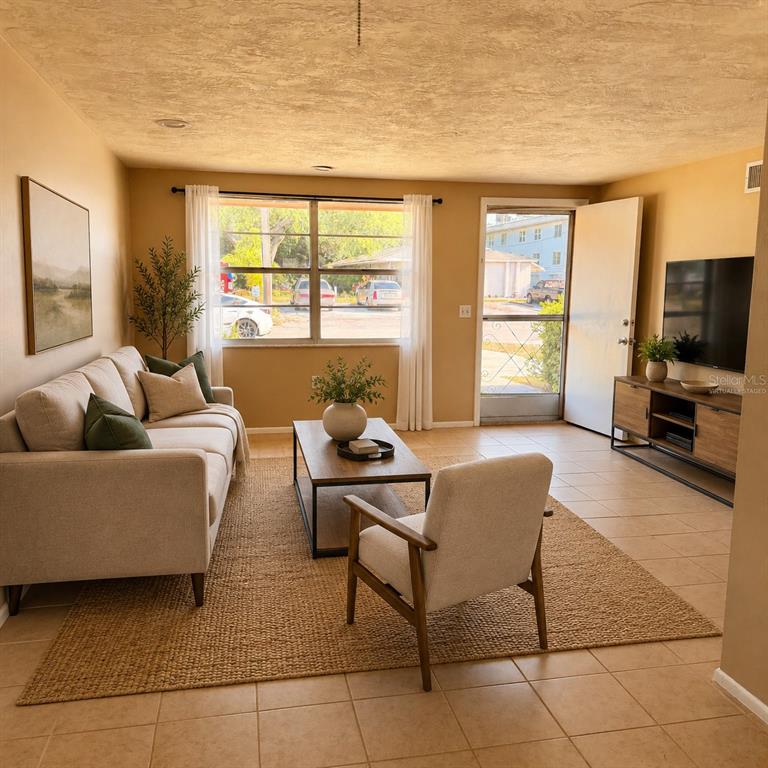 A living room with a beige sofa, armchair, coffee table, and television on a console — 5401 PASADENA DRIVE, NEW PORT RICHEY, FL