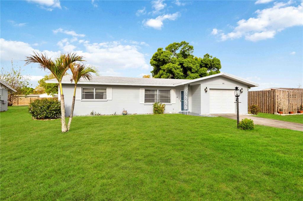 A single-story house with a gray exterior, a one-car garage, and a large front lawn — 181 SANDHURST DRIVE, VENICE, FL