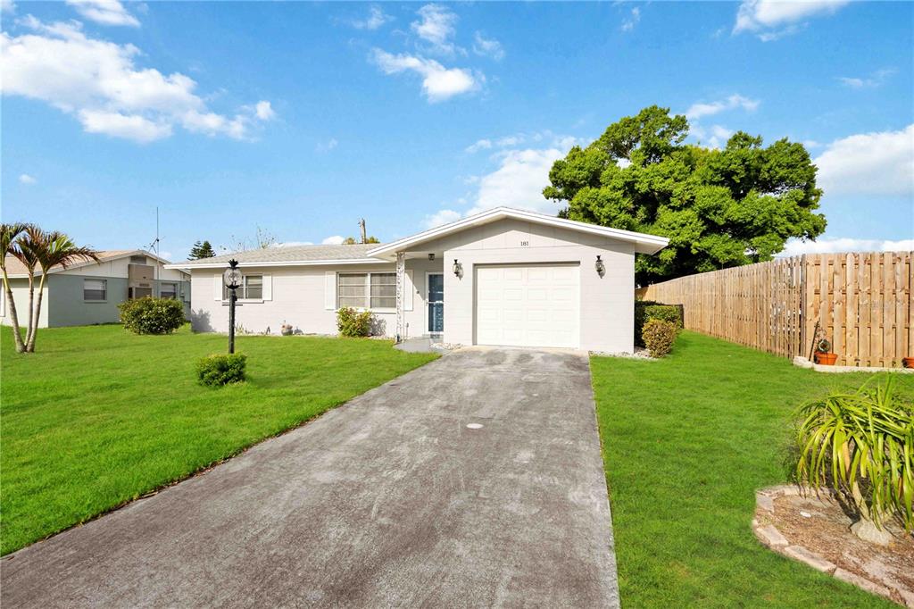 A single-story house with a white garage, gray exterior, and a concrete driveway — 181 SANDHURST DRIVE, VENICE, FL