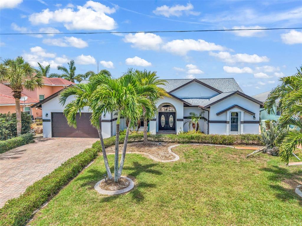 A single-story house with a brown garage, palm trees, and a paved driveway — 12558 BACCHUS ROAD, PORT CHARLOTTE, FL