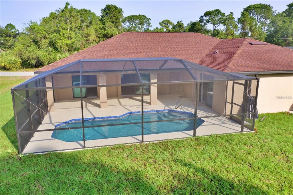 An aerial view of a backyard swimming pool enclosed by a screened lanai — 4851 KENNETT STREET, NORTH PORT, FL