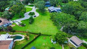 An aerial view shows a vacant grassy lot situated between several houses and a cul-de-sac — 4638 LITTLE GROVE LANE, LAKELAND, FL