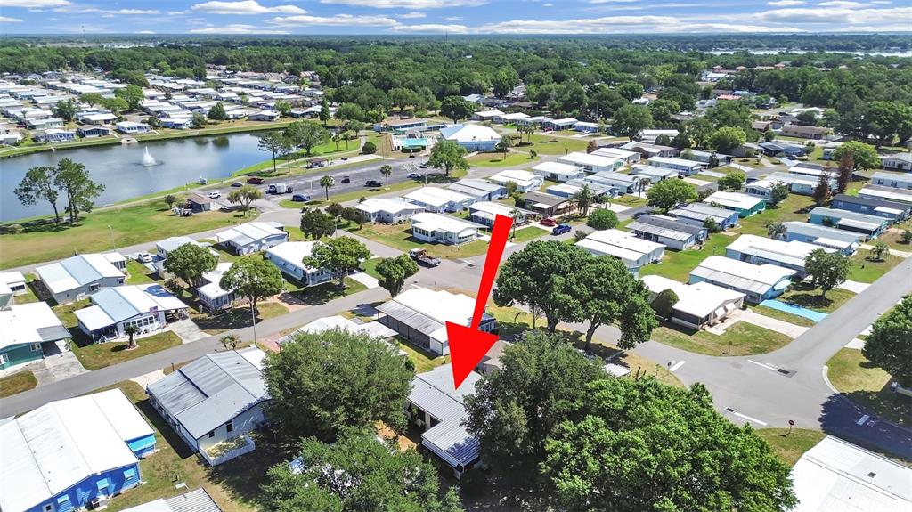 An aerial view shows a mobile home community with a red arrow pointing to a house — 1688 FOXWAY DR, LAKELAND, FL