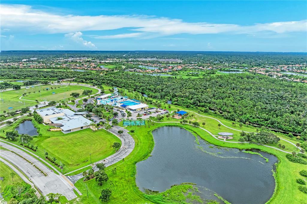 An aerial view shows a community center with a pool, water slide, and large pond — Lot 28 ZINKLE STREET, NORTH PORT, FL
