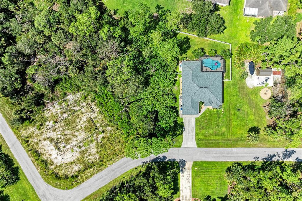 An aerial view shows a house with a pool, a driveway, and a vacant lot — Lot 28 ZINKLE STREET, NORTH PORT, FL