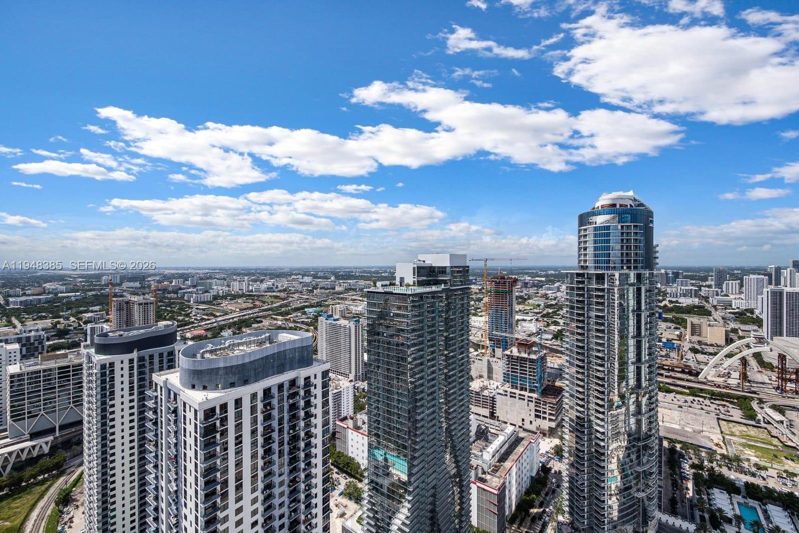 An aerial view shows several modern high-rise buildings in a dense urban city landscape — 159 NE 6th St # 5101, Miami FL 33132, MIAMI, FL