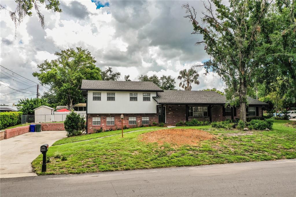 A two-story house with a brick and white siding exterior sits on a grassy lot — 4504 MOUNT VIEW DRIVE, LAKELAND, FL