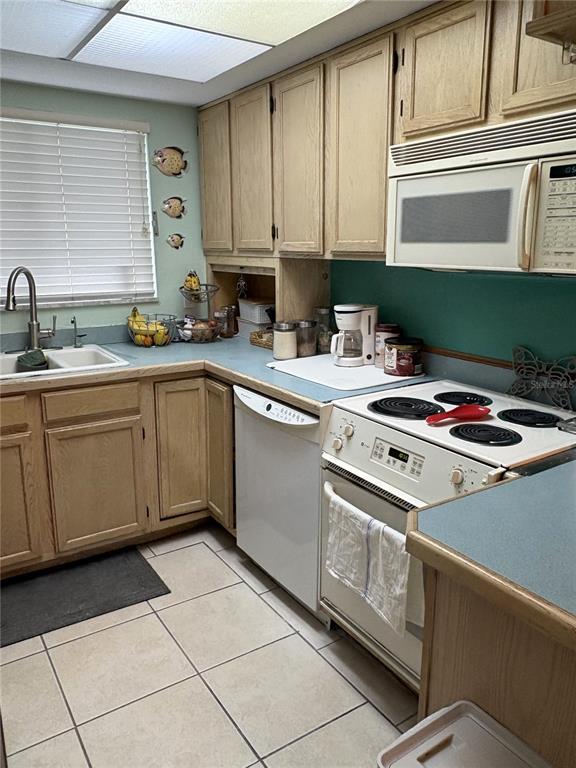 A kitchen features light wood cabinets, teal countertops, white appliances, and tiled flooring — 1200 37TH STREET N UNIT 107, ST PETERSBURG, FL
