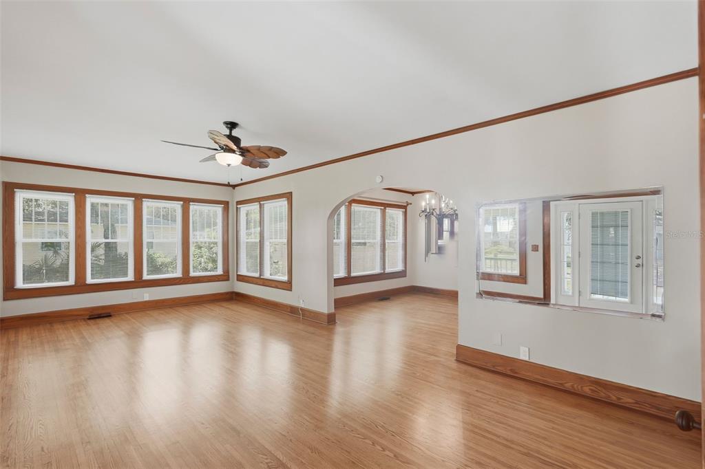 A living room with hardwood floors, crown molding, a ceiling fan, and an arched doorway — 4227 2ND AVENUE N, ST PETERSBURG, FL