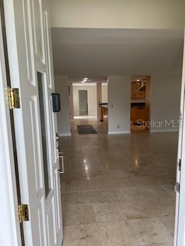 A view through an open white front door into a tiled living area and kitchen — 300 BRIGHTWATERS BOULEVARD NE, ST PETERSBURG, FL
