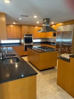 A kitchen features light wood cabinetry, a large central island, and dark granite countertops — 300 BRIGHTWATERS BOULEVARD NE, ST PETERSBURG, FL