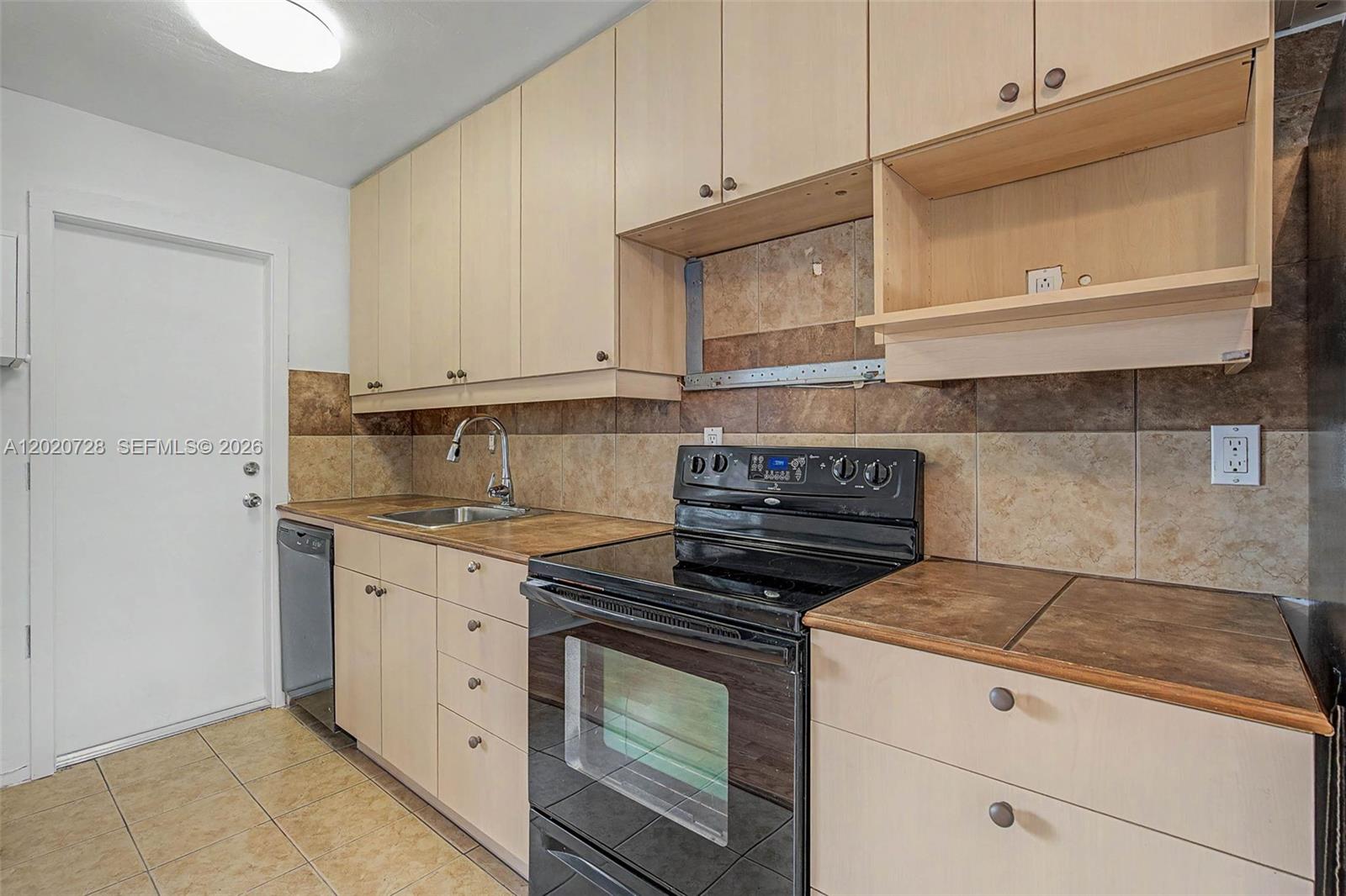 A kitchen features light wood cabinets, dark tile countertops, and a black electric range — 60 NW 79th St # 6, Miami FL 33150, MIAMI, FL