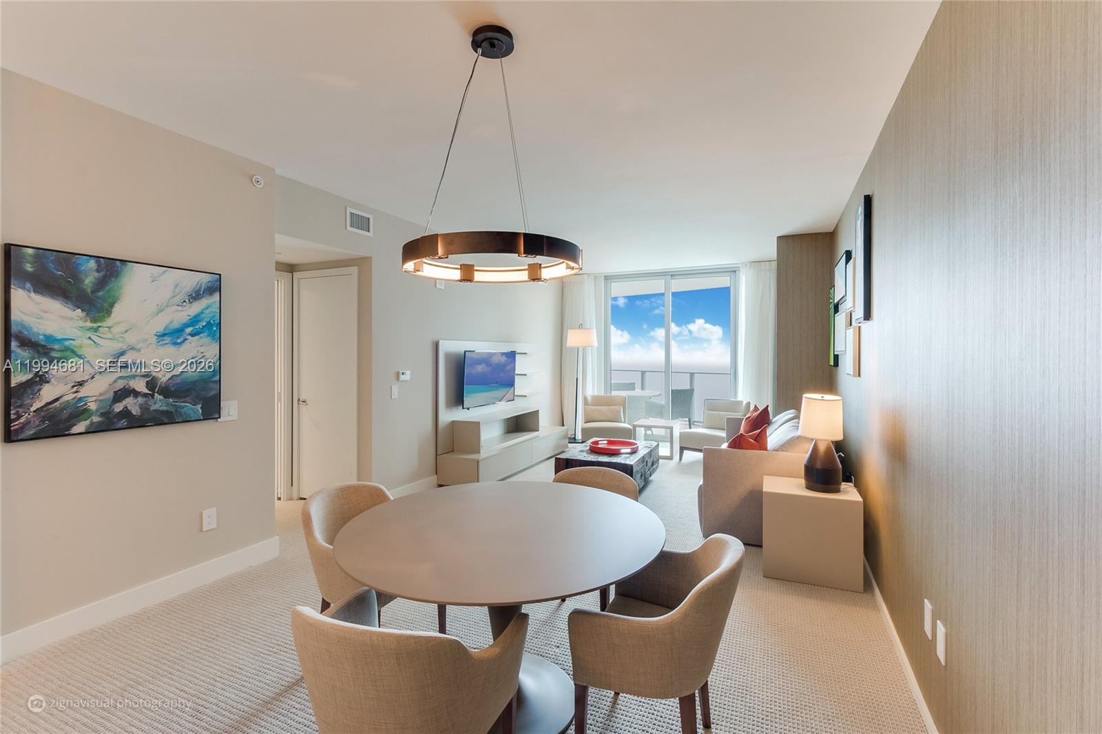 A dining area with a round table and chairs opens into a living room — 4111 S Ocean Dr # 2707, Hollywood FL 33019, HOLLYWOOD, FL
