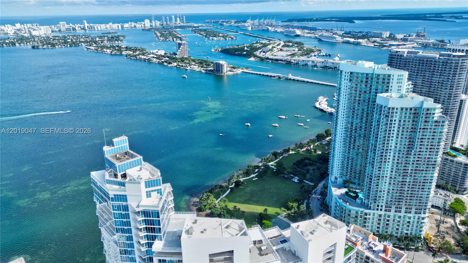 An aerial view shows high-rise buildings overlooking a bay with islands and a bridge — 2020 N Bayshore Dr # 1905, Miami FL 33137, MIAMI, FL