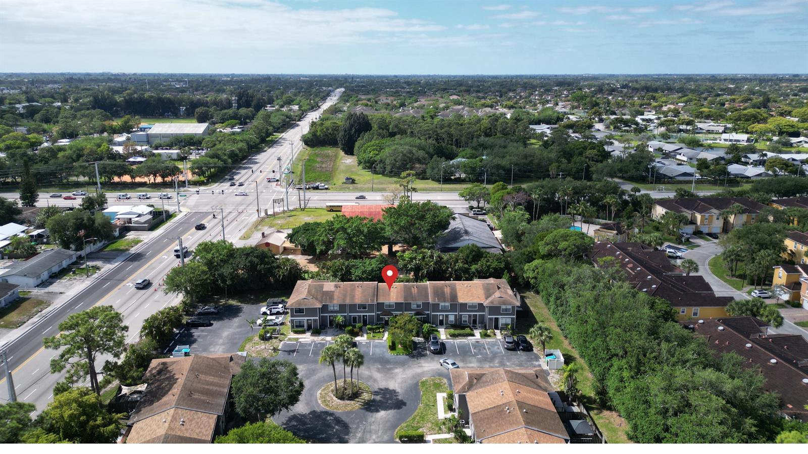 An aerial view shows a multi-unit townhouse building with a parking lot and surrounding trees — 850 Hill Drive # D, West Palm Beach FL 33415, WEST PALM BEACH, FL