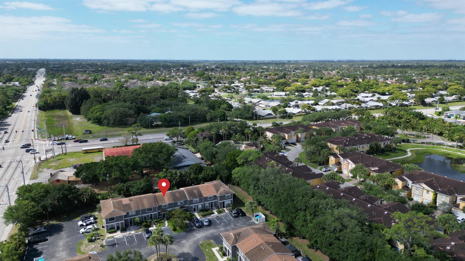 An aerial view shows a multi-unit townhouse complex with a parking lot and surrounding trees — 850 Hill Drive # D, West Palm Beach FL 33415, WEST PALM BEACH, FL