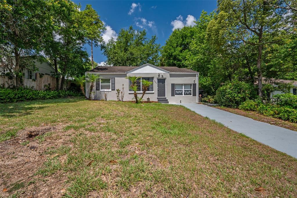A single-story house with a gray exterior, a front door, and a concrete driveway — 7204 N 15TH STREET, TAMPA, FL