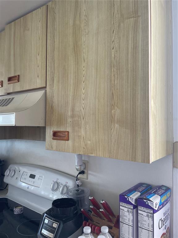 A kitchen features light wood-grain cabinets, a white stove, and a countertop with appliances — 5279 ISLA KEY BLVD UNIT 217, ST PETERSBURG, FL