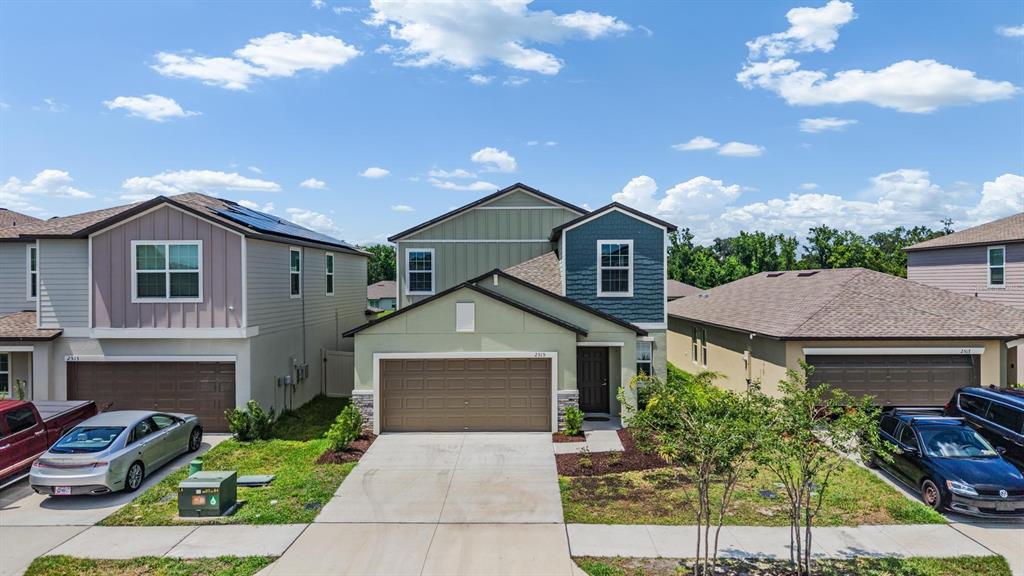 A two-story suburban house with a light green exterior and a two-car garage — 2515 VICTORIOUS FALLS AVENUE, PLANT CITY, FL