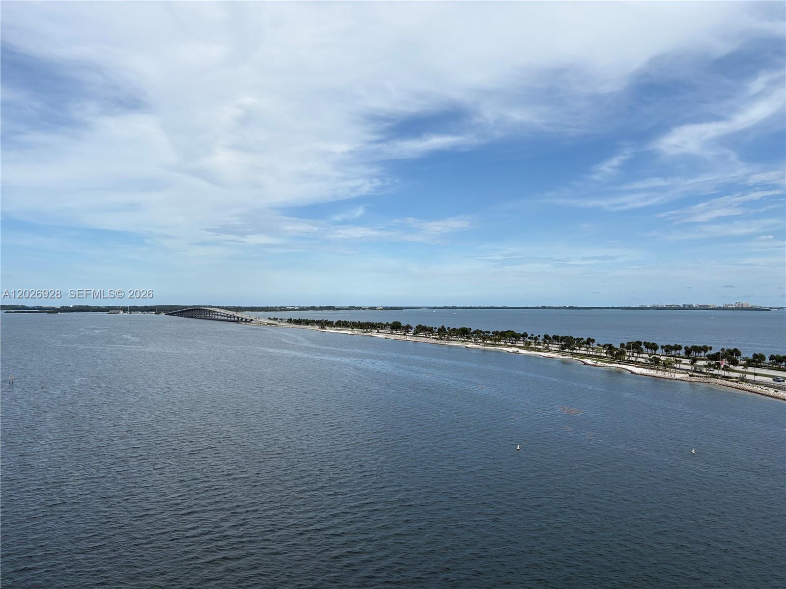 An aerial view shows a long causeway bridge extending across a large body of water — 175 SE 25 Road # 901, Miami FL 33129, MIAMI, FL