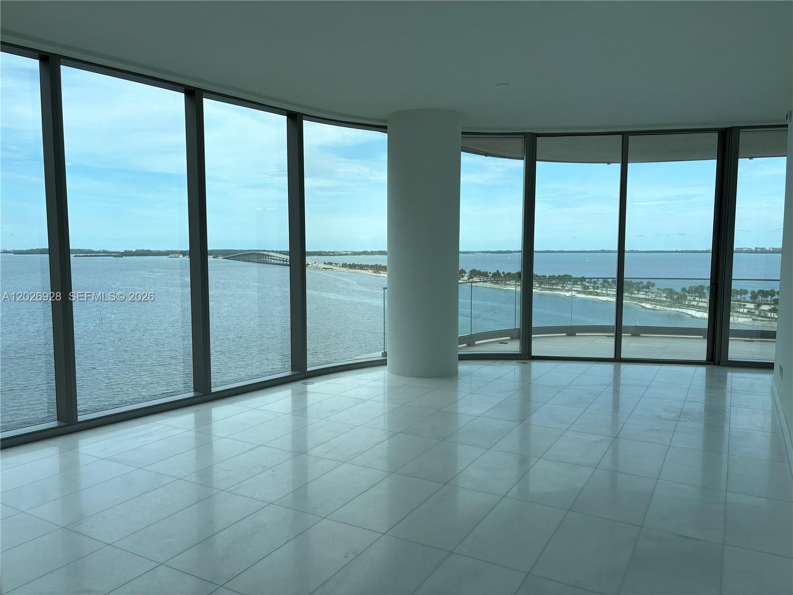 An empty room with white tile floors and floor-to-ceiling windows overlooking a bay — 175 SE 25 Road # 901, Miami FL 33129, MIAMI, FL