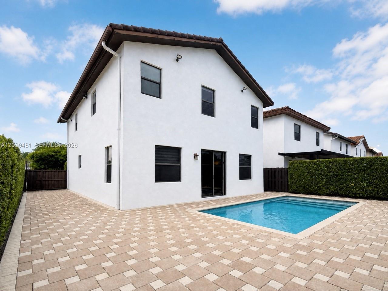 A two-story white house features a backyard patio with a swimming pool and hedges — 8605 NW 102nd Ct, Doral FL 33178, DORAL, FL