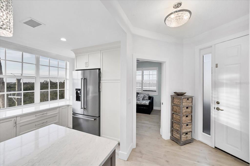 A kitchen with white cabinets, a stainless steel refrigerator, and a doorway to another room — 13113 GASPARILLA ROAD UNIT 405, PLACIDA, FL