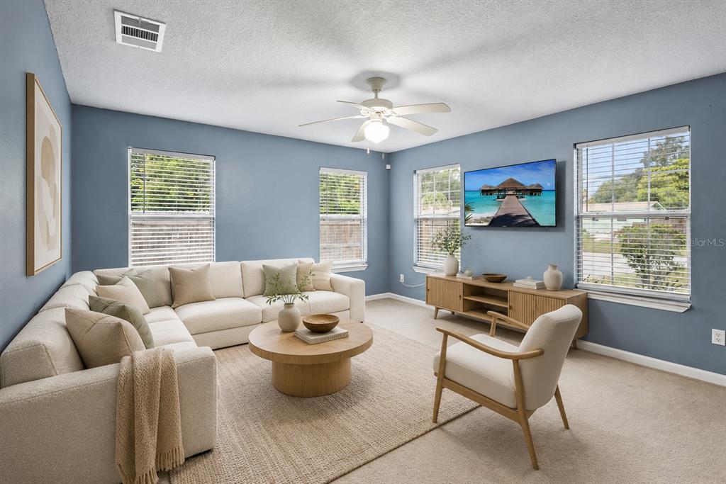A living room features a large sectional sofa, a round coffee table, and a television — 4532 HUPPEL AVENUE, ORLANDO, FL