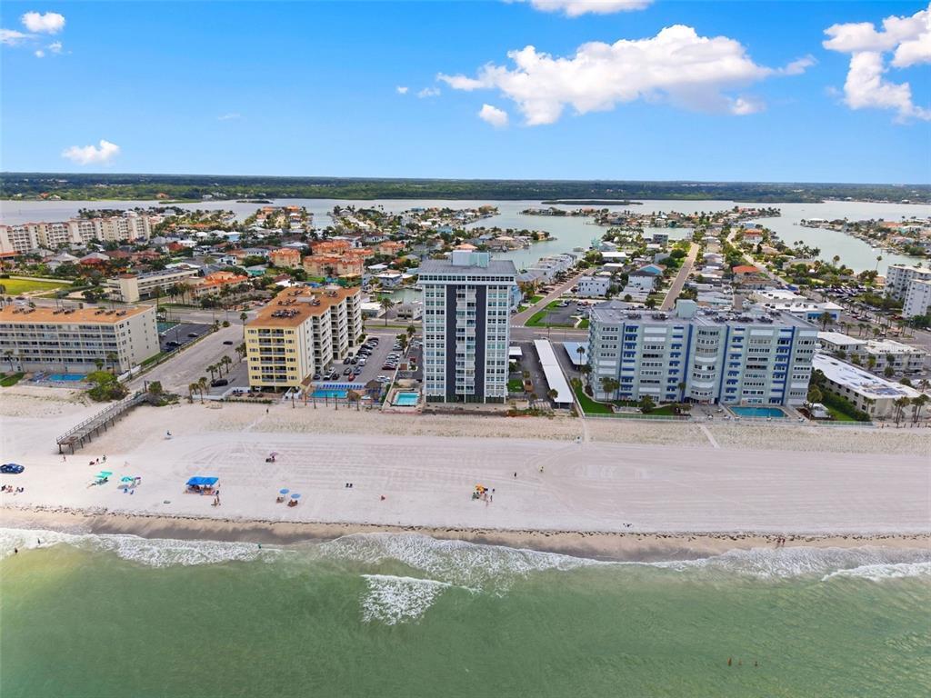 An aerial view shows three beachfront apartment buildings along a sandy beach and ocean — 17408 GULF BOULEVARD UNIT 403, REDINGTON SHORES, FL