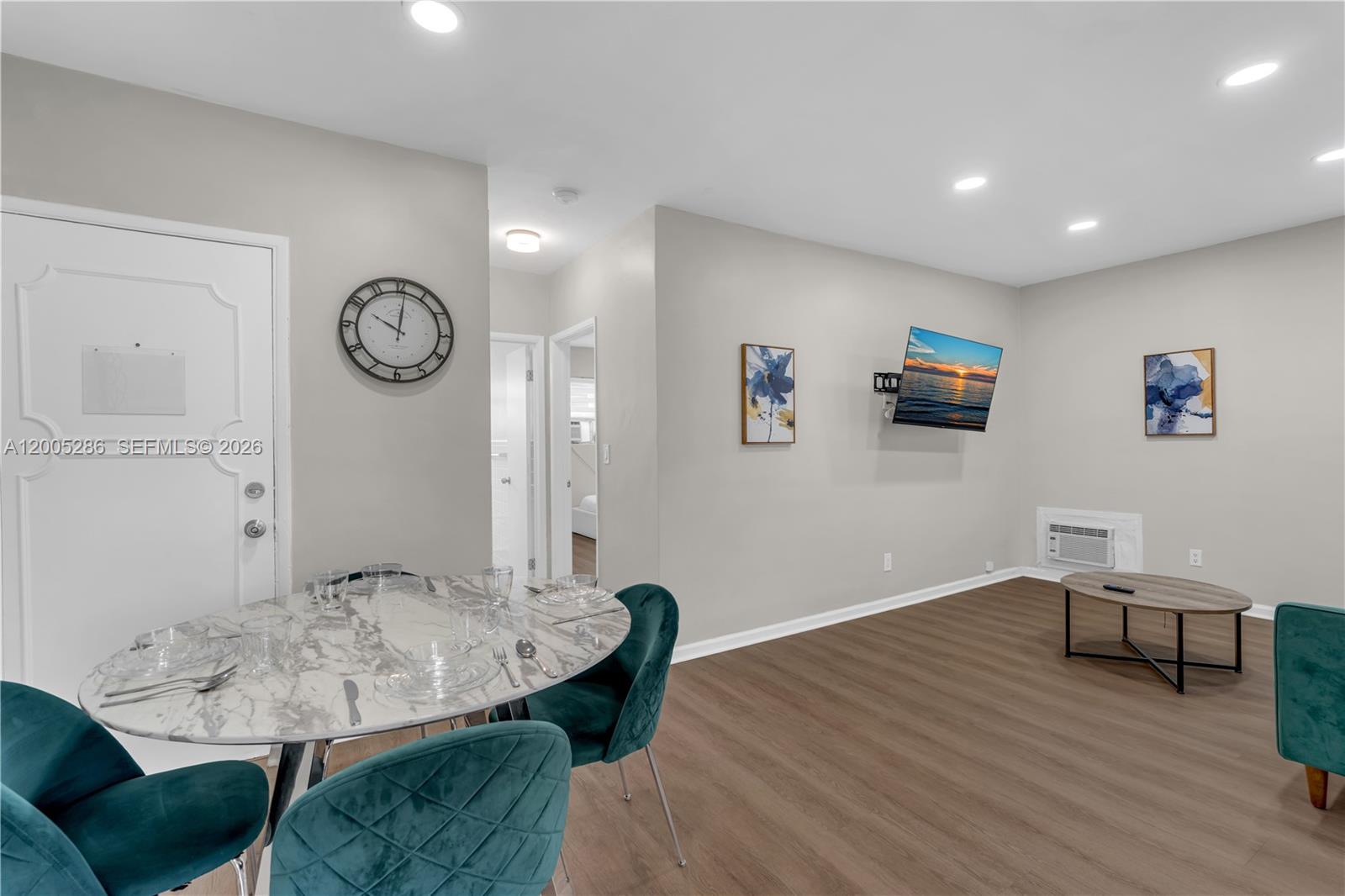 A dining area with a marble table and teal chairs opens into a living space — 10006 E Bay Harbor Dr # 15, Bay Harbor Islands FL 33154, BAY HARBOR ISLANDS, FL