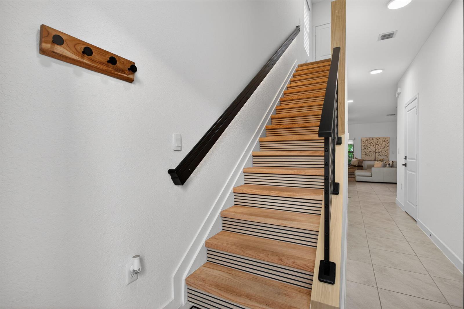 A staircase with wood treads and slatted risers features a black handrail and metal railing — 873 NW 3rd Way, Pompano Beach FL 33060, POMPANO BEACH, FL