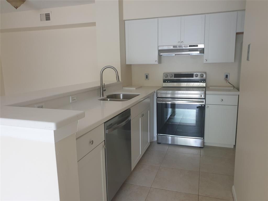 A kitchen features white cabinets, stainless steel appliances, and a peninsula with a sink — 520 S Park Road # 12, Hollywood FL 33021, HOLLYWOOD, FL