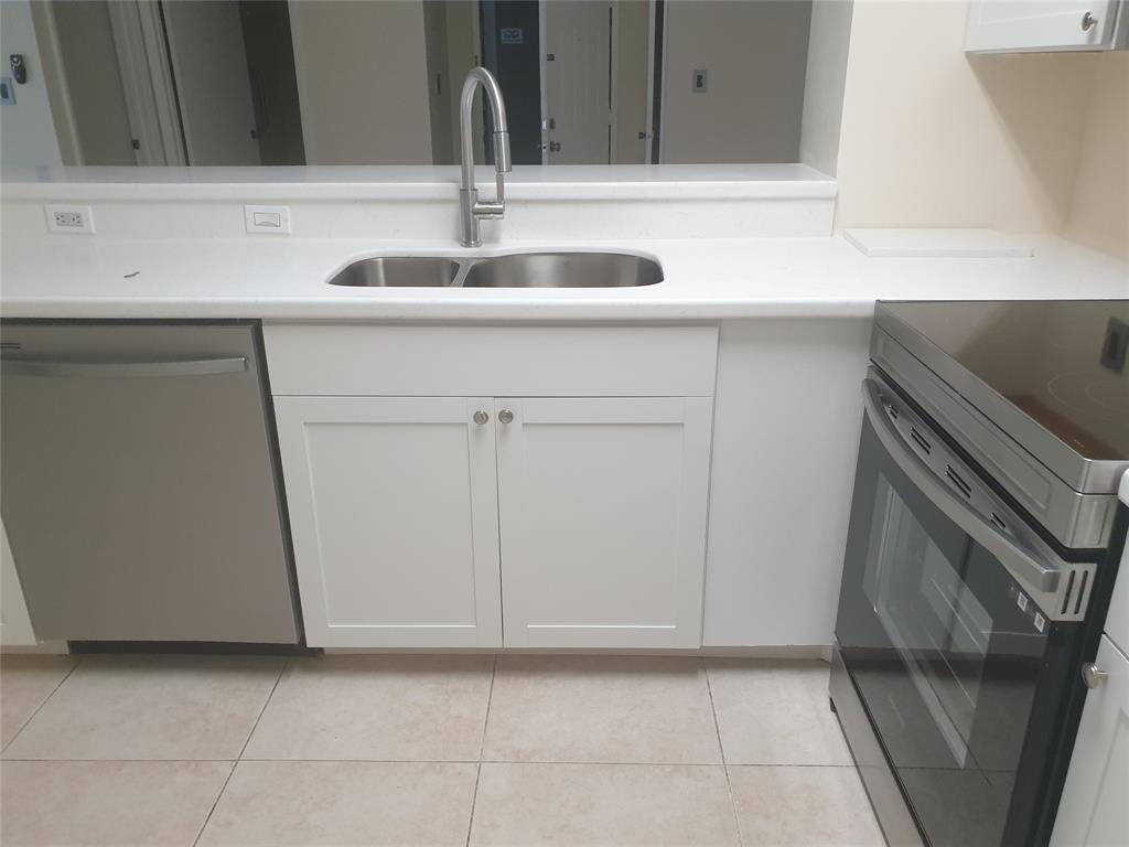 A kitchen features white cabinets, a stainless steel sink, a dishwasher, and a glass-top stove — 520 S Park Road # 12, Hollywood FL 33021, HOLLYWOOD, FL