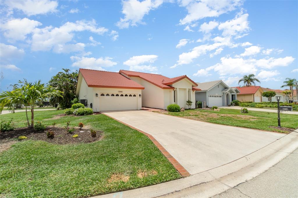 A single-story house with a red tile roof and a concrete driveway in a neighborhood — 12601 KELLY PALM DRIVE, FORT MYERS, FL