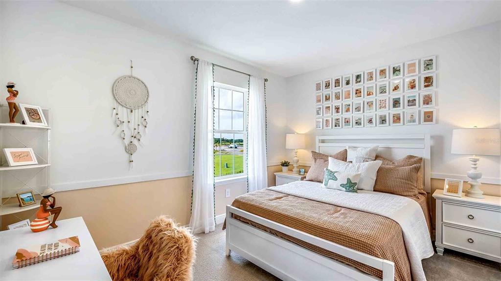 A bedroom features a white bed, a desk, a window, and a gallery wall — 18211 THISTLEBERRY PLACE, LAKEWOOD RANCH, FL