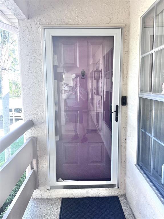 A two-story residential building features screened-in porches on the rear exterior — 7828 HARDWICK DRIVE UNIT 927, NEW PORT RICHEY, FL