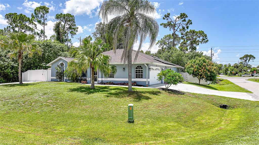 A single-story blue house with a palm tree in the front yard and a driveway — 1632 AMSTEAD STREET, PORT CHARLOTTE, FL