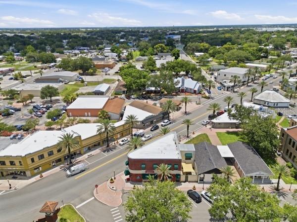 An aerial view of a small town street featuring commercial buildings, palm trees, and parking — 119 MAIN STREET, AUBURNDALE, FL
