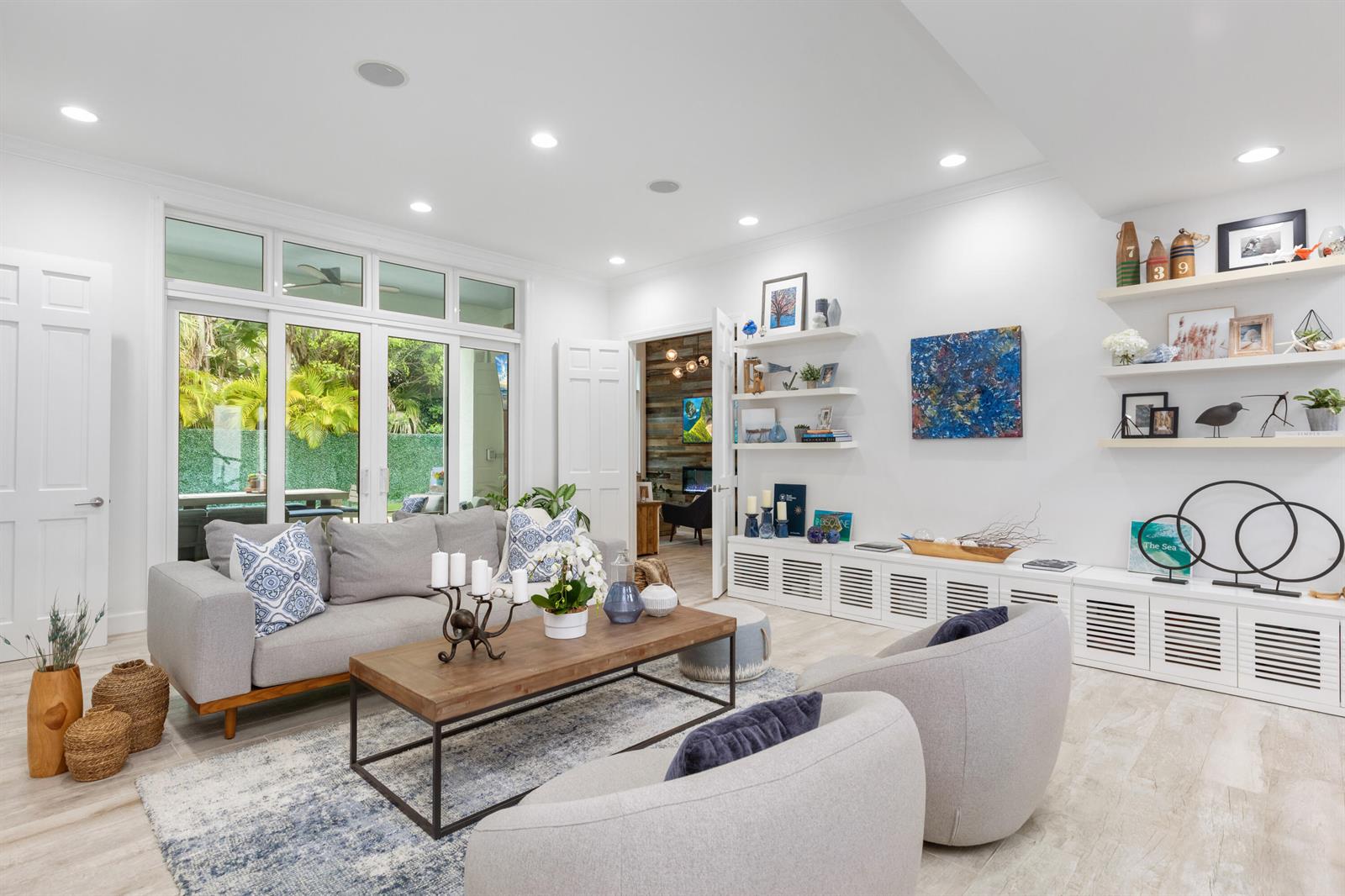 A bright living room features a gray sofa, two armchairs, a coffee table, and built-in shelving — 24 Grand Bay Estates Circle, Key Biscayne FL 33149, KEY BISCAYNE, FL