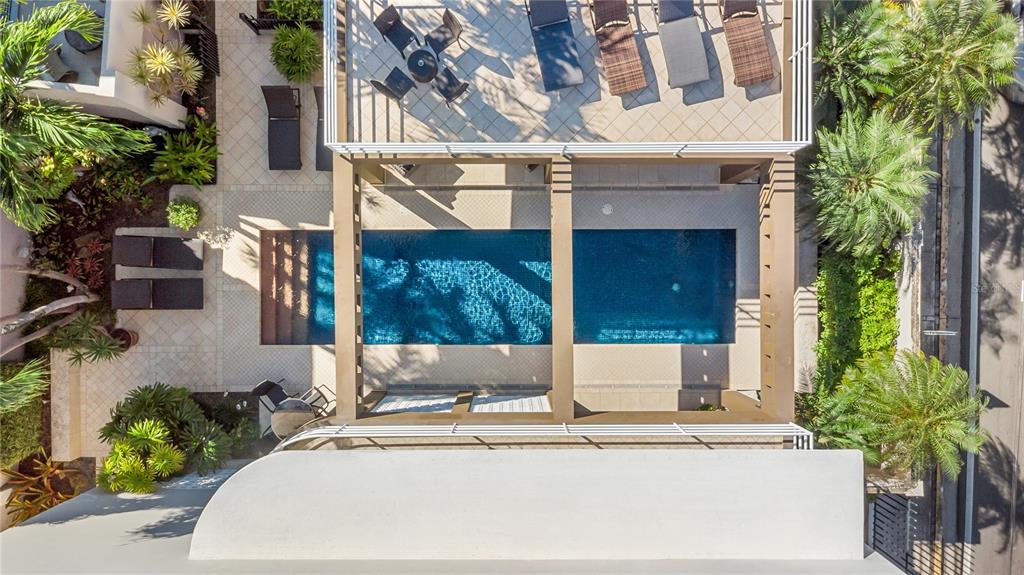 An aerial view shows a rectangular swimming pool beneath a pergola, surrounded by lounge furniture — 1858 MCLEARY, SAN JUAN, PR