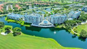 An aerial view shows a multi-story apartment complex situated along a lake and golf course — 2333 FEATHER SOUND DRIVE UNIT B304, CLEARWATER, FL