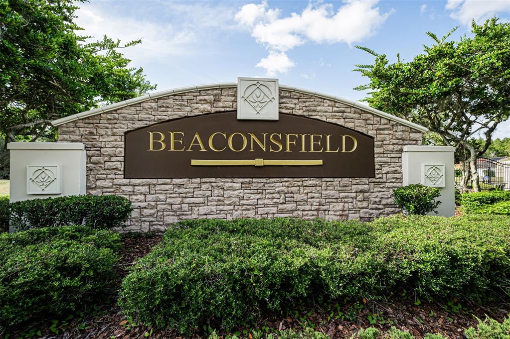 A stone entrance sign for a community named Beaconsfield sits surrounded by green landscaping — 1629 SALMONBERRY STREET, WESLEY CHAPEL, FL