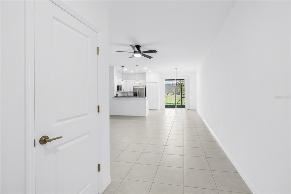 A view from a doorway looking into an open-concept kitchen and living area with tile floors — 9305 BONITA MAR DRIVE, PARRISH, FL