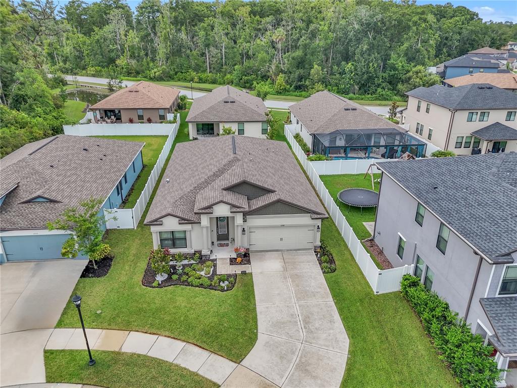 An aerial view shows a suburban house with a driveway, lawn, and fenced backyard — 12591 VANDER WAY, NEW PORT RICHEY, FL