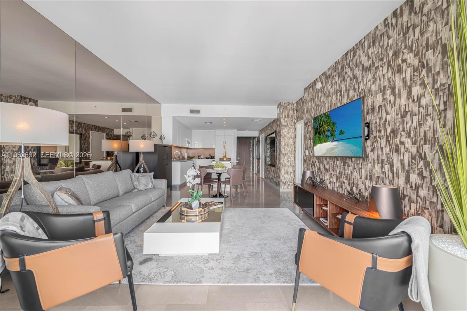 A living room features a grey sofa, two leather armchairs, and a wall-mounted television — 88 SW 7th St # 3806, Miami FL 33130, MIAMI, FL