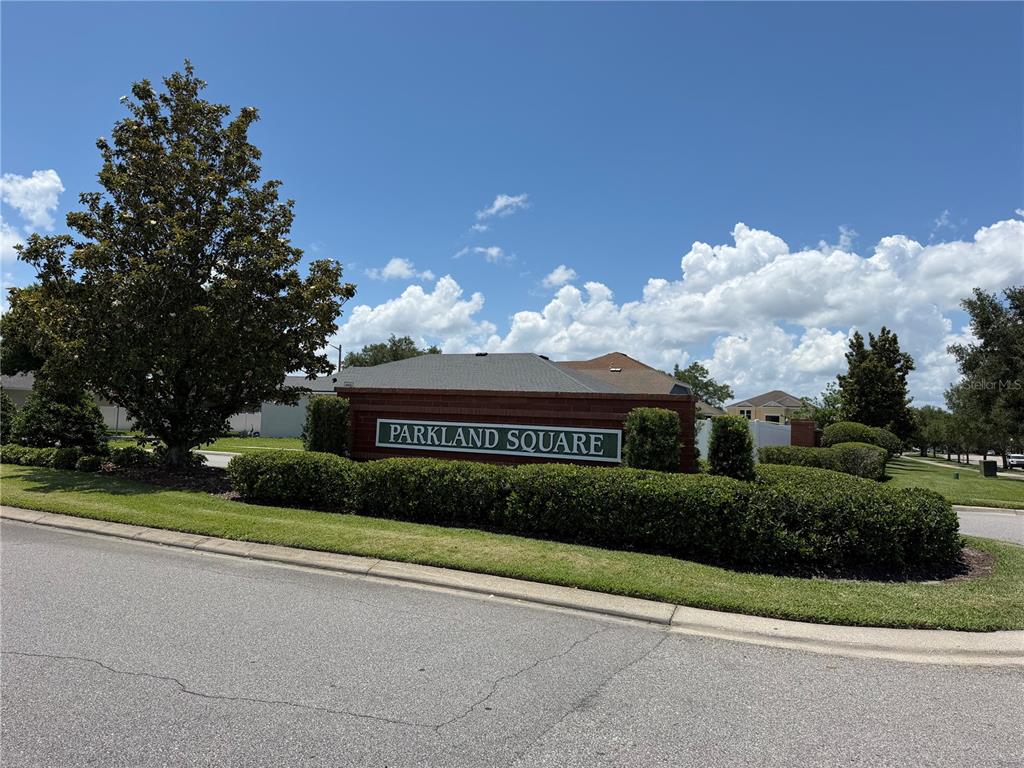 A single-story house with a tan stucco exterior, a two-car garage, and a brick walkway — 945 TRAMELLS TRAIL, KISSIMMEE, FL