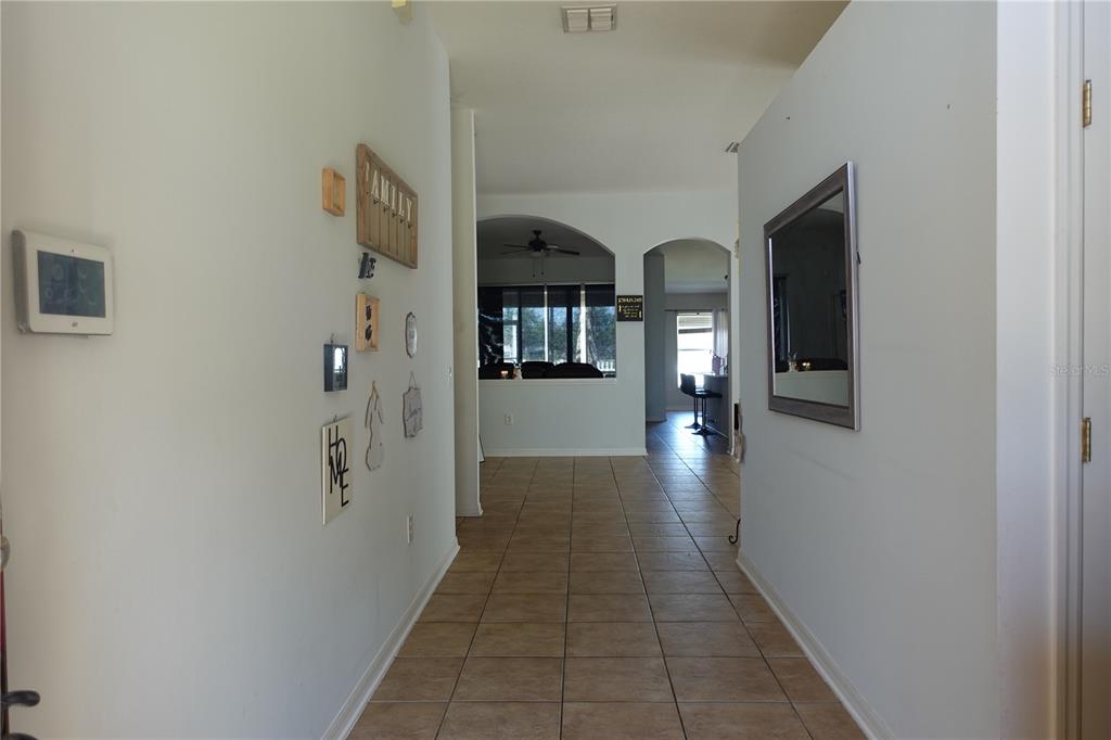 A single-story house features a two-car garage, a brick walkway, and a front entrance — 945 TRAMELLS TRAIL, KISSIMMEE, FL