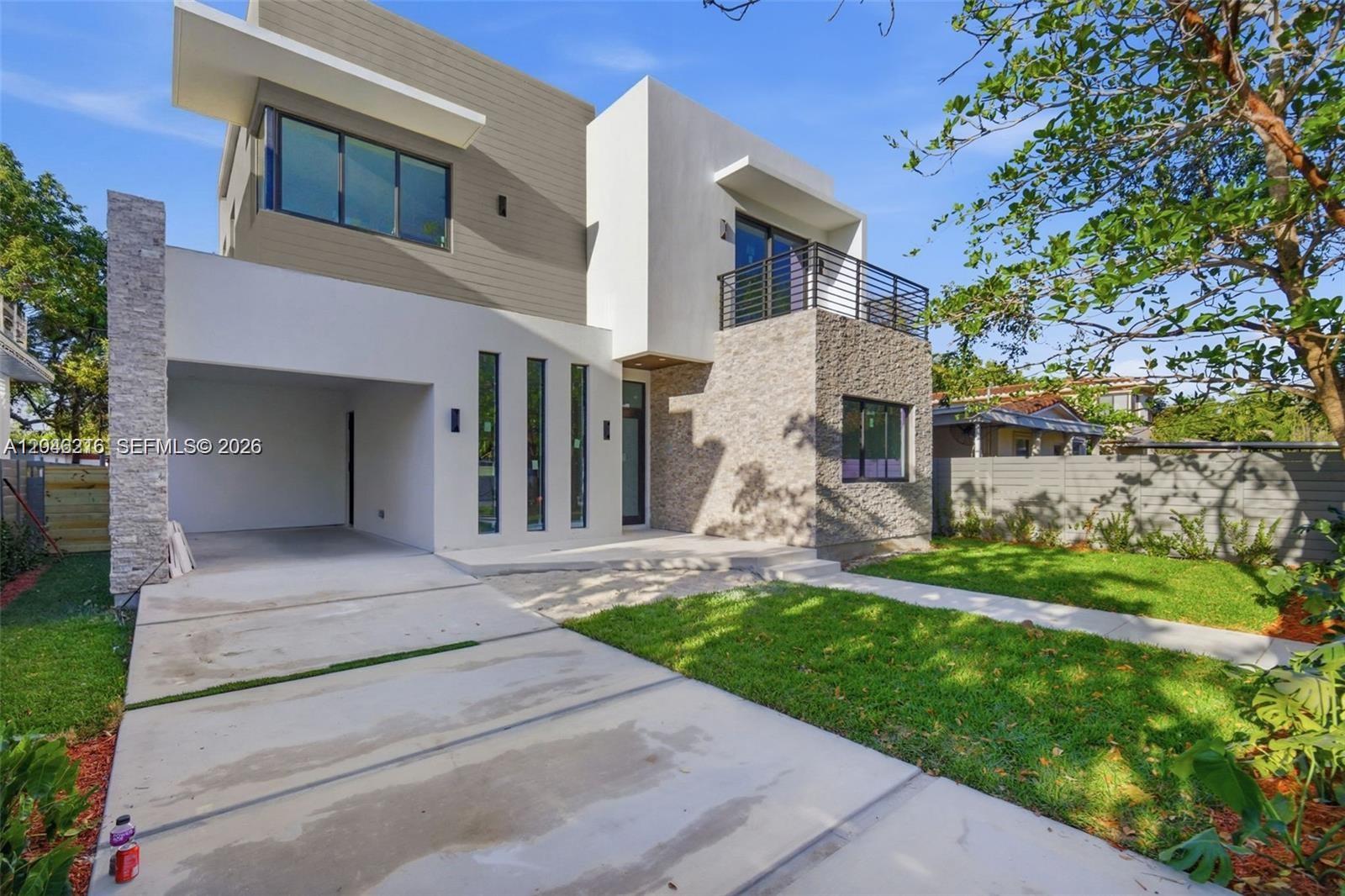 A modern two-story house features a stone facade, a garage, and a second-floor balcony — 3545 Florida Ave, Miami FL 33133, MIAMI, FL